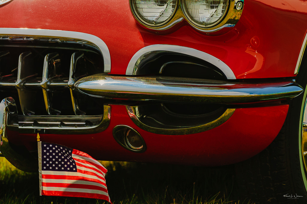 red car on grass with USA flag