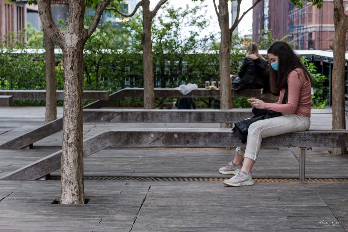 woman sitting, using smartphone, high line, new york city